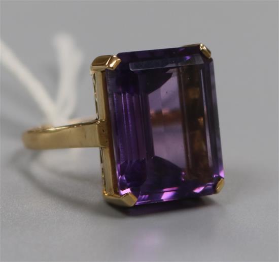 A yellow metal and emerald cut amethyst dress ring, size O.
